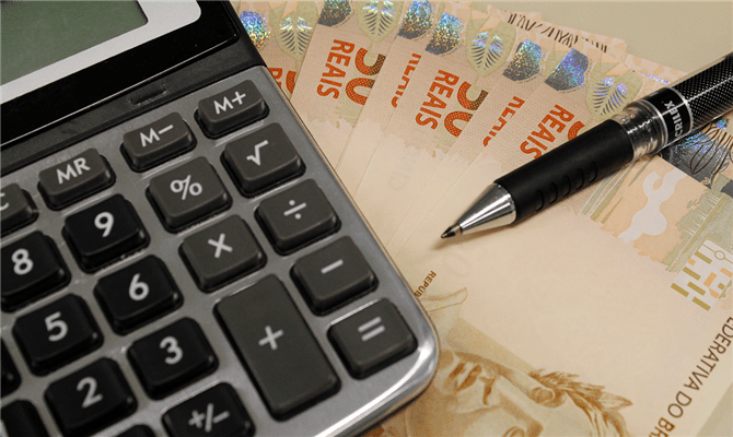 Foto de uma calculadora sendo usada para saber se uma empresa possui crédito de impostos 